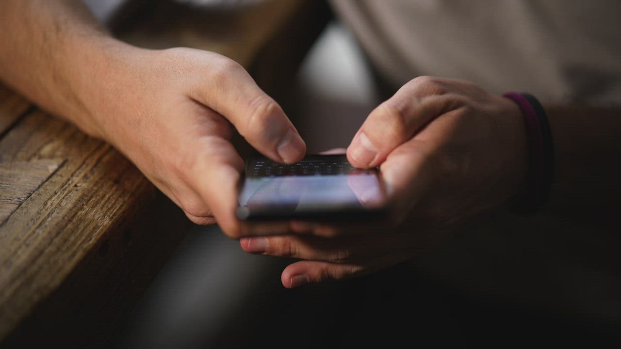 Hands typing on a phone